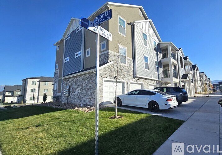 A street view of a residential area with apartment buildings and cars parked on the street.