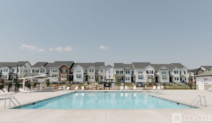 A large swimming pool in front of a row of houses with the word "available" on the bottom right.
