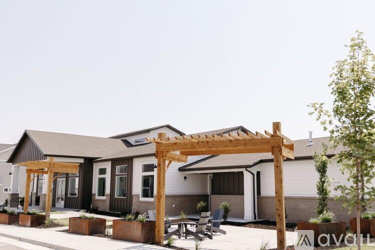 A wooden pergola is in front of a building with a sign that says "avon".