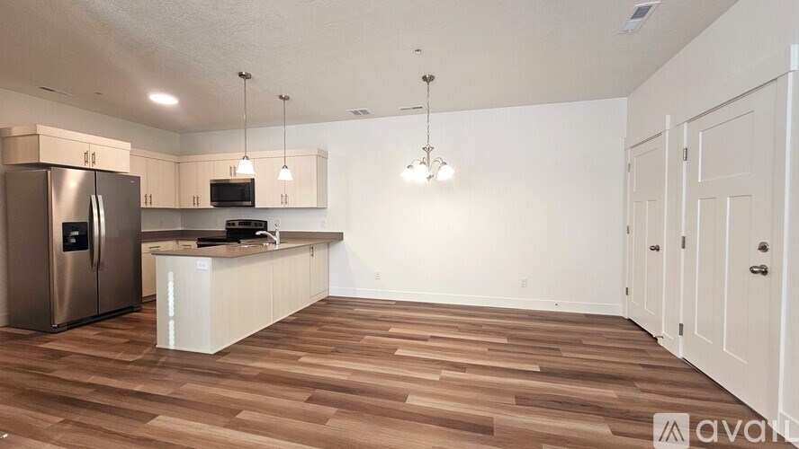 A kitchen with wooden floors and white cabinets.