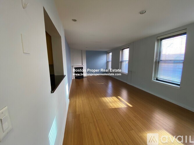 A long hallway with wooden floors and white walls.