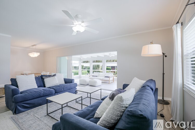 A living room with a blue couch and a white coffee table.
