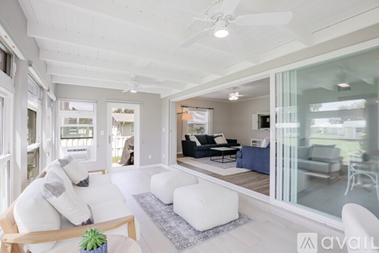 A living room with a white couch and a ceiling fan.