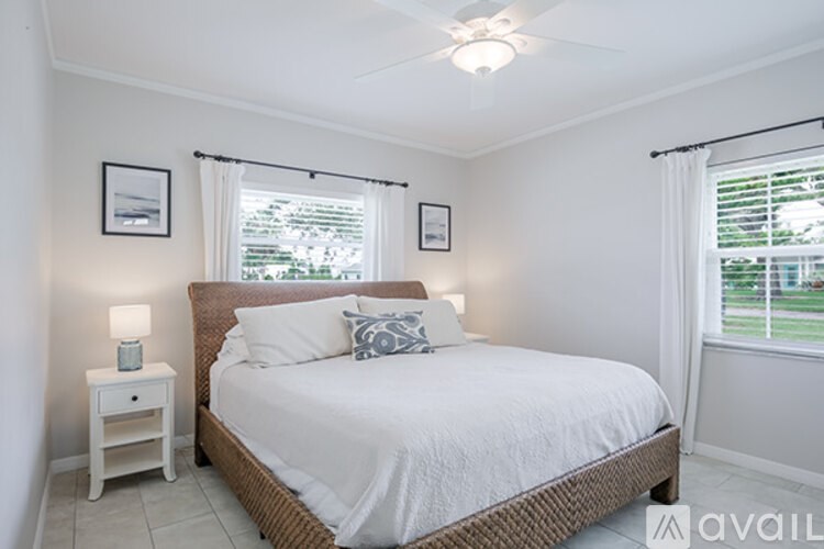 A bedroom with a bed, nightstand, and two pictures on the wall.