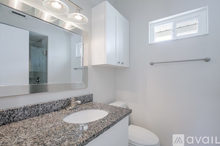A bathroom with granite countertops and a large mirror.