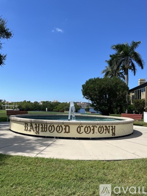 A fountain in the middle of a grassy area with the words "Baywood Cotton" written on it.