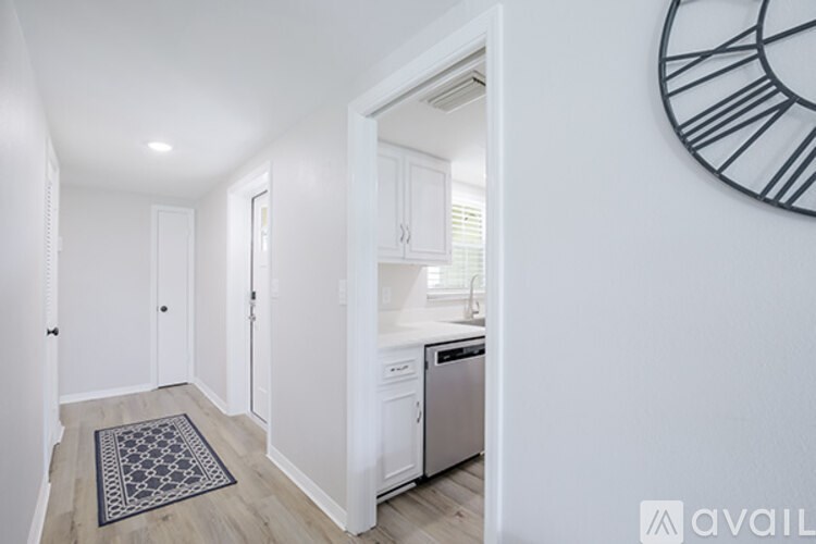 A kitchen area with a white cabinet and a black and white clock on the wall.