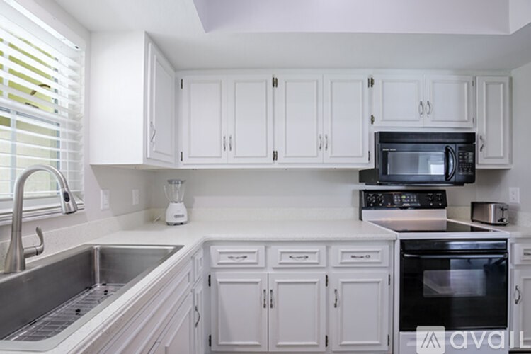 A kitchen with white cabinets and appliances.