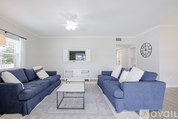 A living room with two blue couches and a white coffee table.