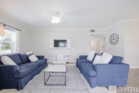 A living room with two blue couches and a white coffee table.
