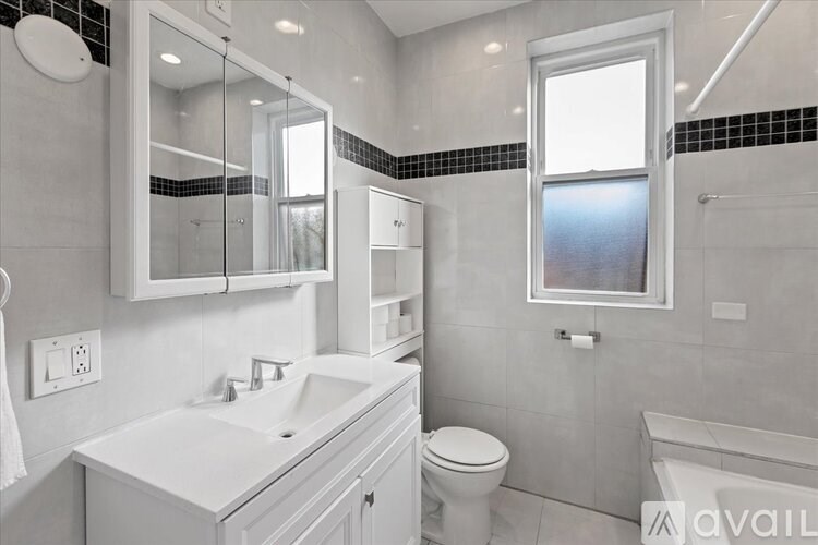 A modern bathroom with a white sink and toilet.