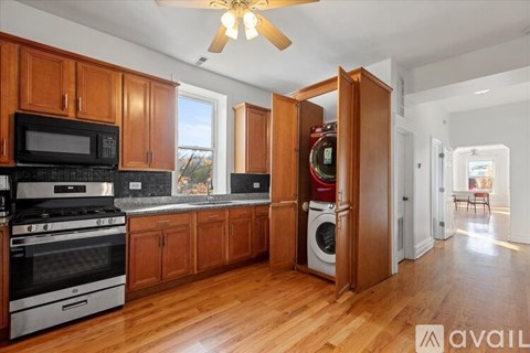 A kitchen with wooden cabinets and a black microwave.