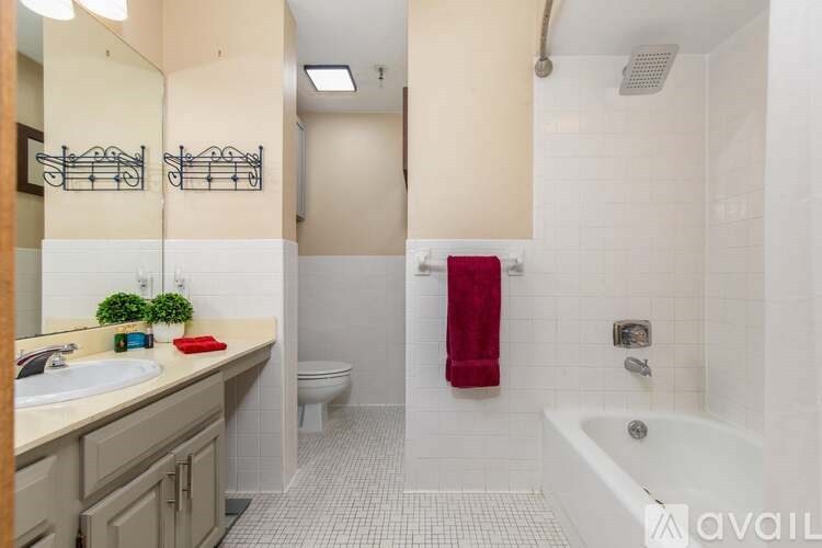 A bathroom with a white tub, sink, and toilet.