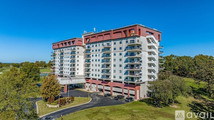 A large multi-story building with a red and white exterior and a parking lot in front.