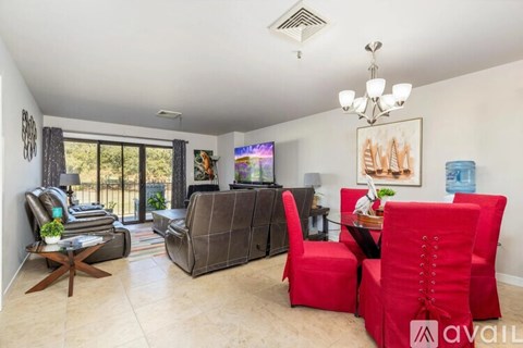 A living room with a red chair and a brown couch.