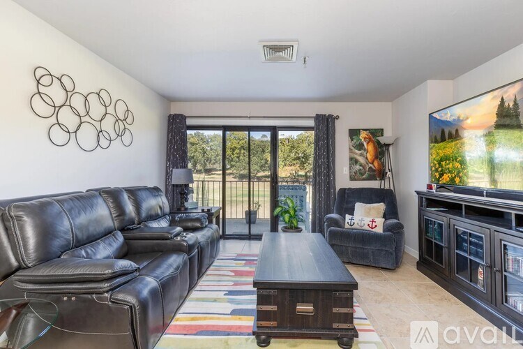 A living room with a black leather couch and a wooden coffee table.