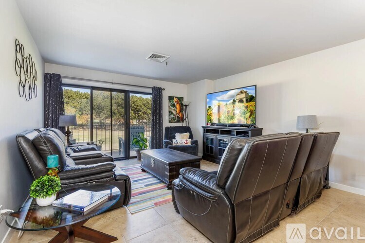 A living room with a large couch, a coffee table, and a flat screen TV.