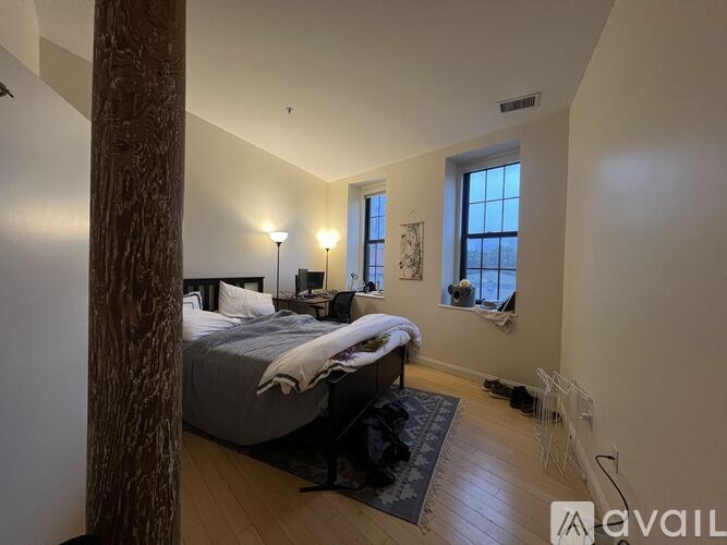 A bedroom with a large bed and a window.