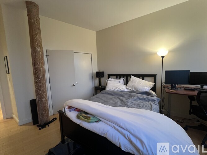 A bedroom with a bed, desk, and chair.