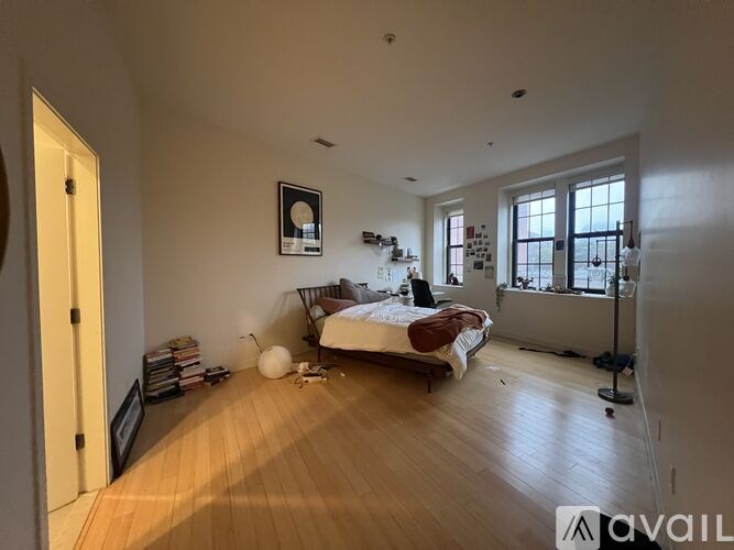 A bedroom with a bed, a window, and a balcony.