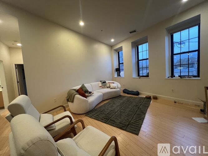 A living room with a white couch and a rug.