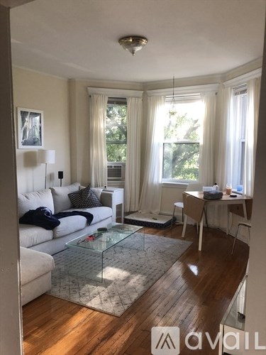 A living room with a white couch and a glass coffee table.