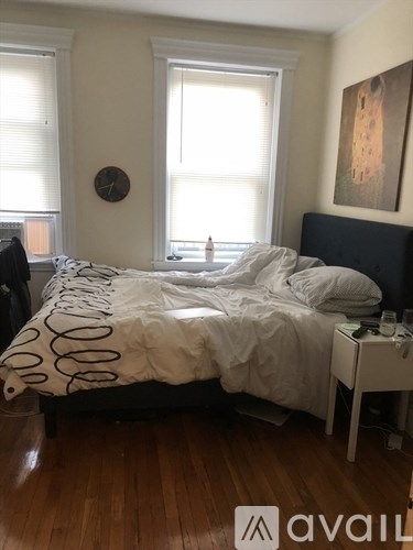 A bedroom with a large bed and a clock on the wall.