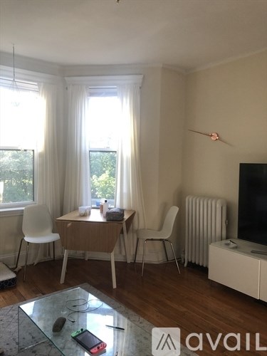 A living room with a glass coffee table and a television.
