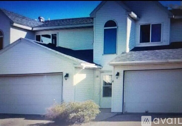 A two-story house with a garage on the right side.