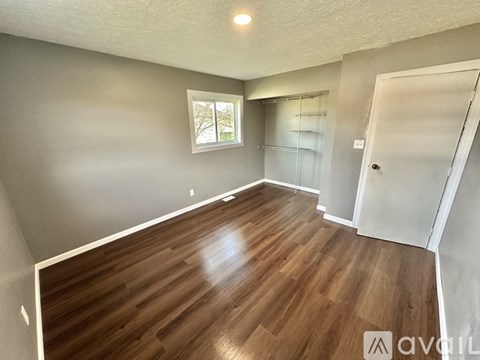 A room with wooden flooring and a window.