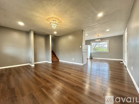 A spacious room with wooden flooring and a ceiling light.