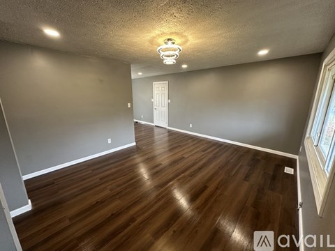 A room with wooden flooring and a white door.
