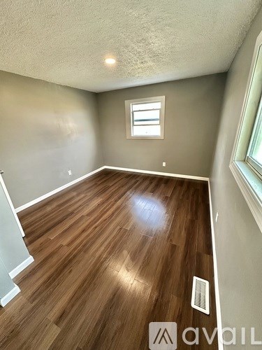A kitchen with white cabinets and a wooden floor.