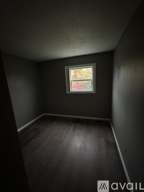 A room with a window and wooden floors.