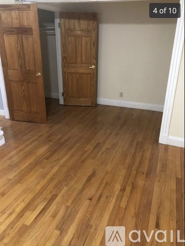 A room with wooden floors and two doors.