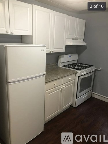 A kitchen with white appliances and cabinets.