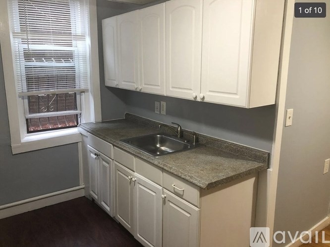 A kitchen with white cabinets and a granite countertop.