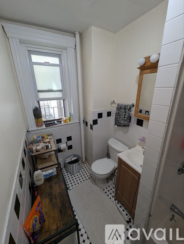 A bathroom with a toilet, sink, and mirror.