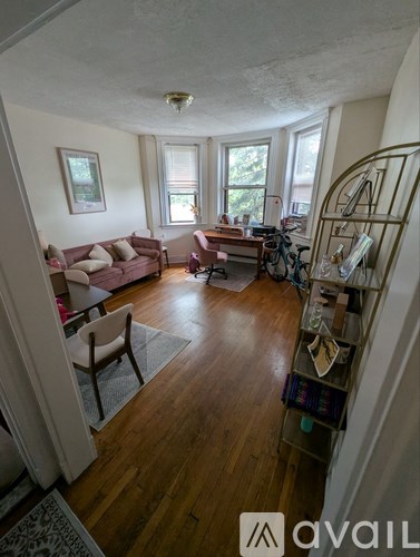 A living room with a couch, chair, and a bicycle.