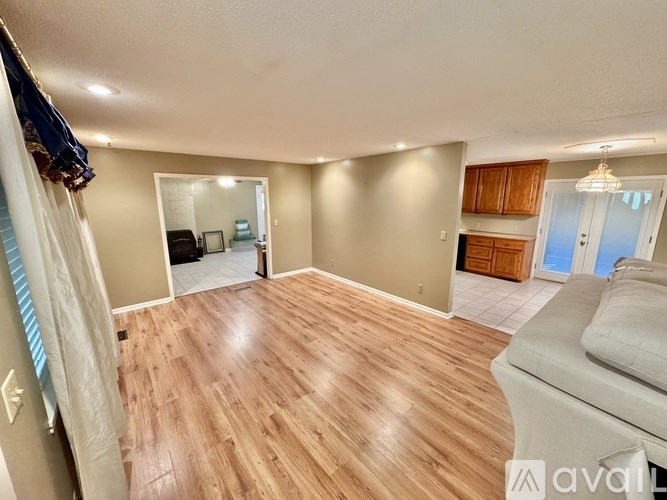 A room with wooden flooring and a mirror on the wall.