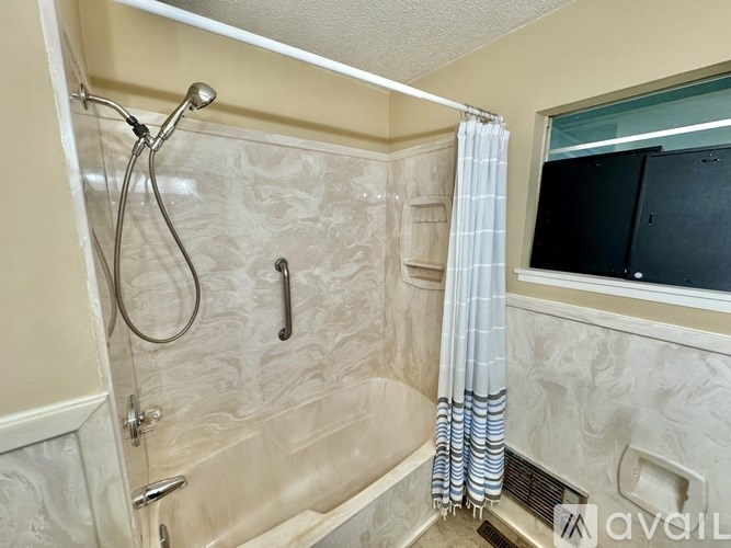 A bathroom with a shower curtain and a glass door.