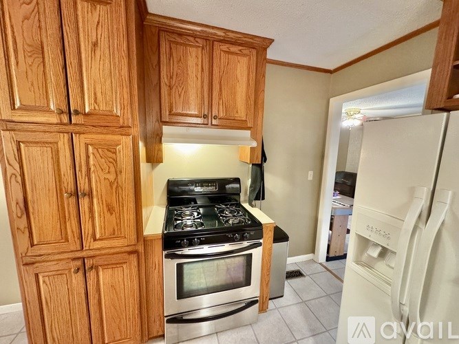 A kitchen with wooden cabinets and a stove top oven.