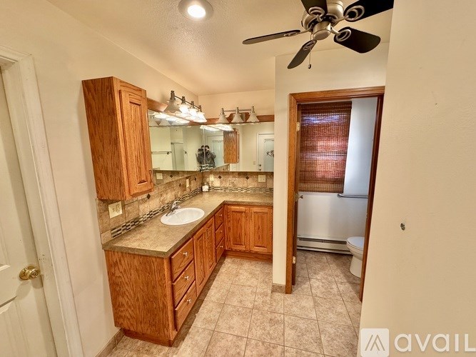 A bathroom with wooden cabinets and a tiled floor.