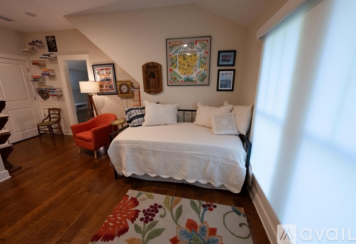 A bedroom with a large bed and a red chair.