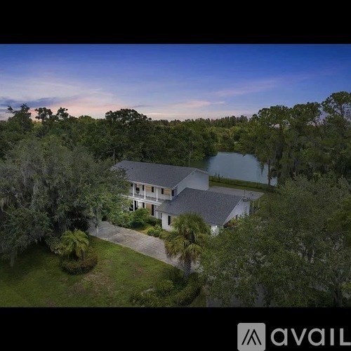 A house surrounded by trees with a clear blue sky.