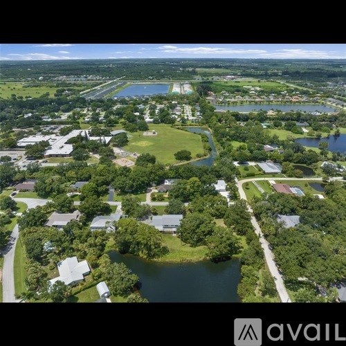 A bird's eye view of a residential area with a lake and greenery.