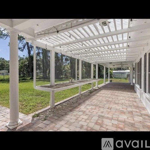 A covered walkway with white columns and a white roof.
