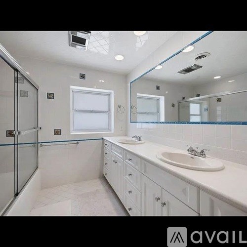 A bathroom with a white sink and a large mirror.