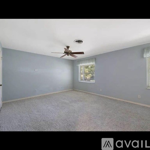 A room with a ceiling fan and a window.