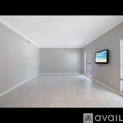 A spacious room with a television mounted on the wall.